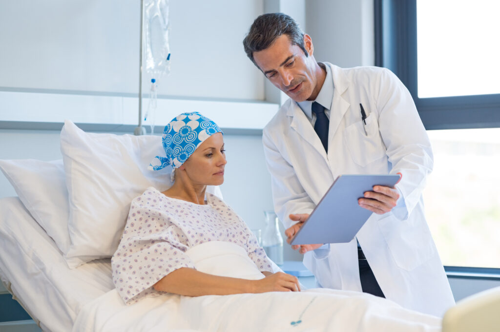 Doctor telling to patient woman the results of her medical tests. Doctor showing medical records to cancer patient in hospital ward. Senior doctor explaint the side effects of the intervention.