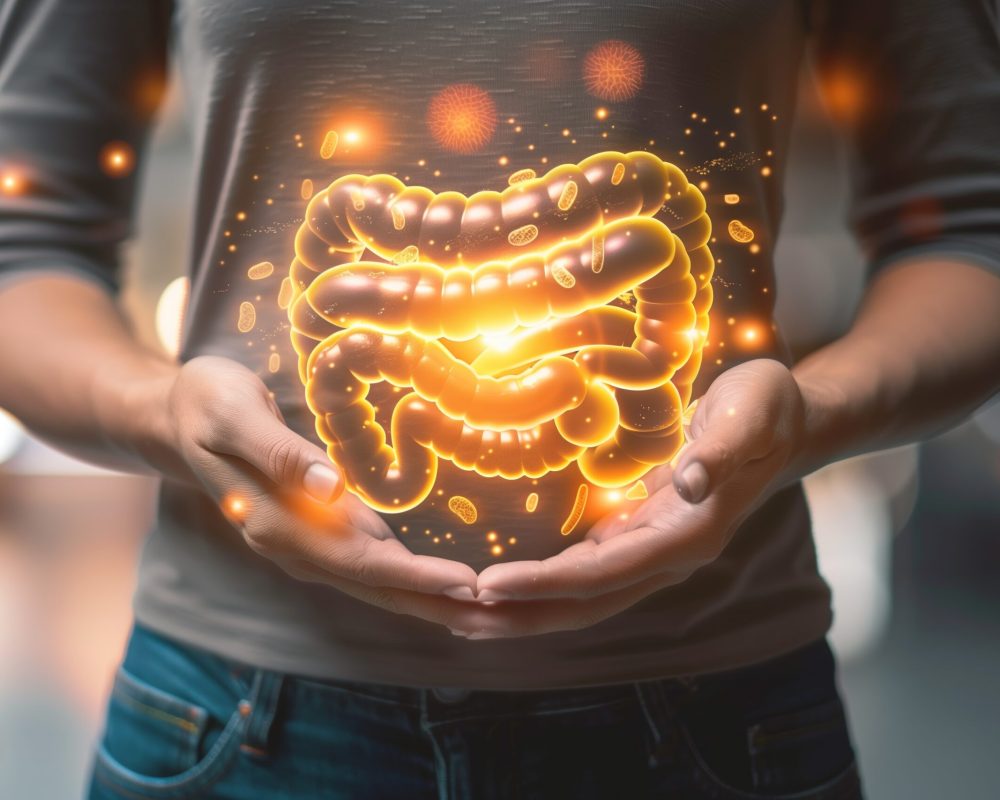 a person with a stomach ache holding their hands over their stomach with an illustration of intestines super imposed over top
