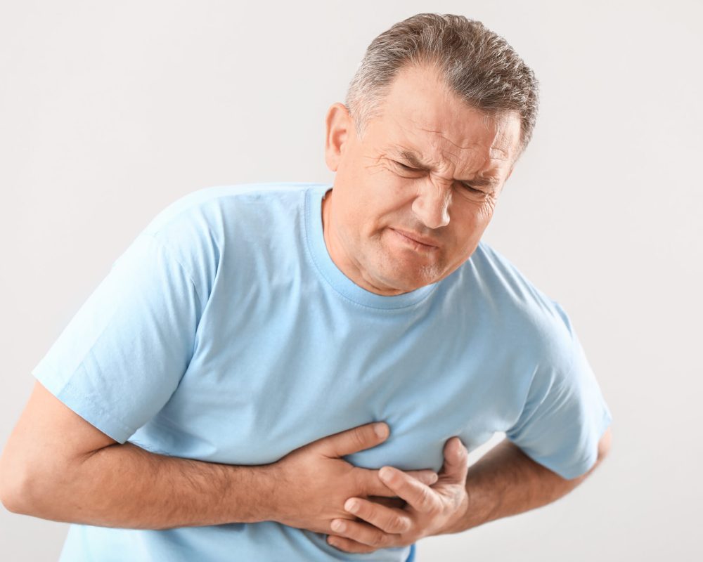 Mature man suffering from heart attack on white background